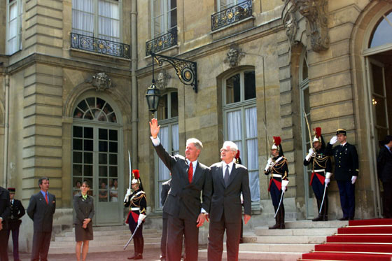 President Clinton, accompanied by French Prime Minister Lionel Jospin, waves to the crowd outside the Prime Minister's residence, Htel Matignon.